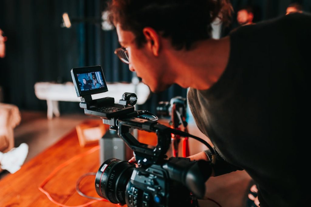 Man filming on set with professional video camera in studio setting.